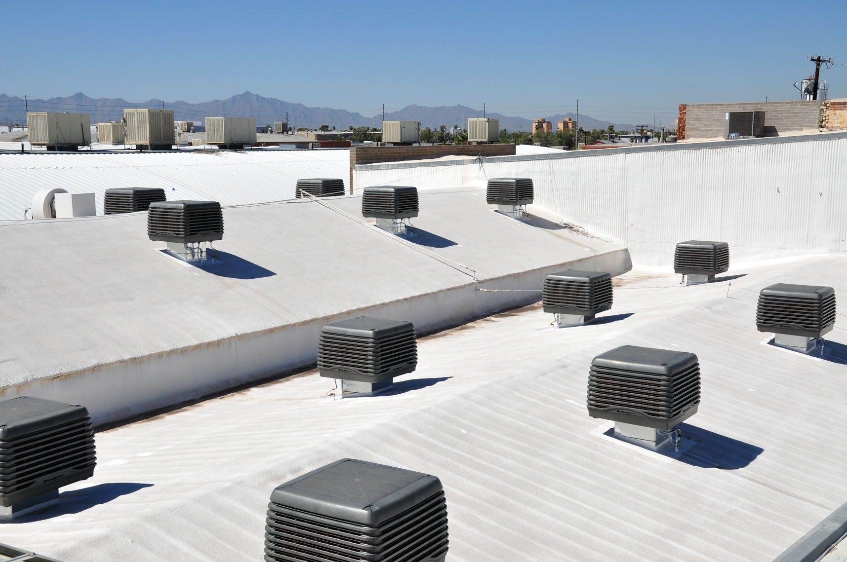multiple evaporative cooling units installed in the roof of a factory