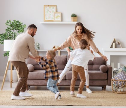 happy family mother father and children dancing at home happy family mother father and kids daughter and son dancing and having fun at home