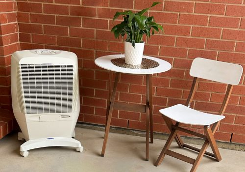 portable cooler on patio with white chair and table